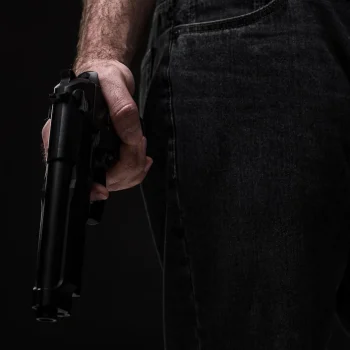 assassino-com-arma-em-fundo-preto-no-estudio_639032-217